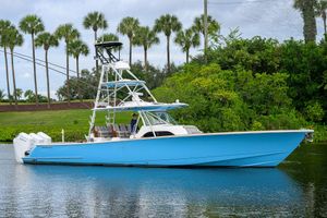 Valhalla Boatworks V-46 2023 Valhalla Boatworks vessel in blue, cruising on a scenic waterway with lush greenery.