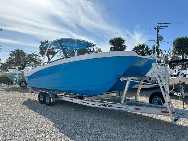 Twin Vee 280 GFX DC 2024 Twin Vee 280 GFX DC boat on a trailer in a sunny outdoor setting.