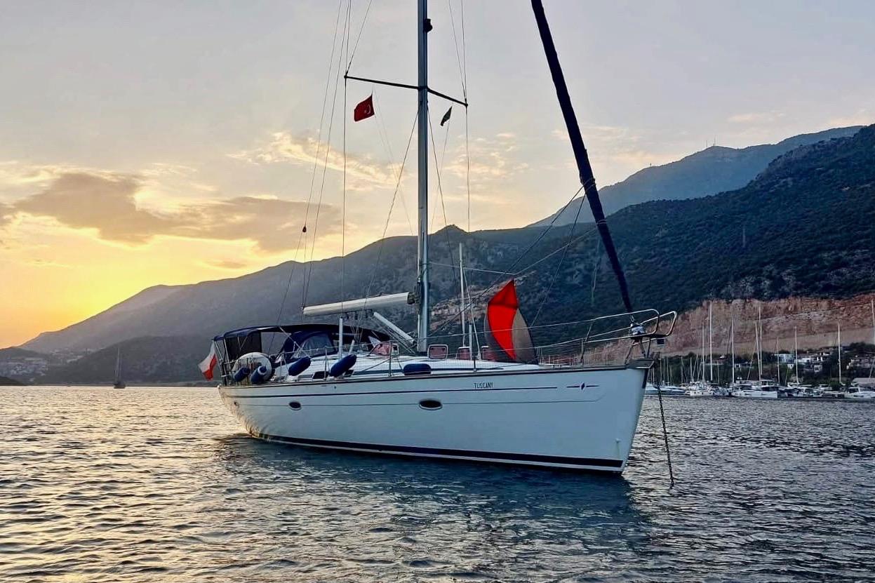 Bavaria Cruiser 46 Bavaria 46 Cruiser 2007 yacht at sunset, anchored near mountainous coastline.