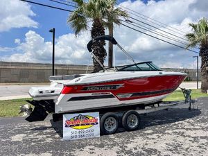 Monterey 218SS Super Sport 2024 Monterey 218 SS boat in red and white on a trailer, parked outdoors.