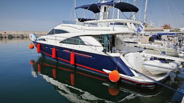 Fairline Squadron 58 2009 Fairline Squadron 58 yacht docked in a marina, featuring sleek design and vibrant fenders.