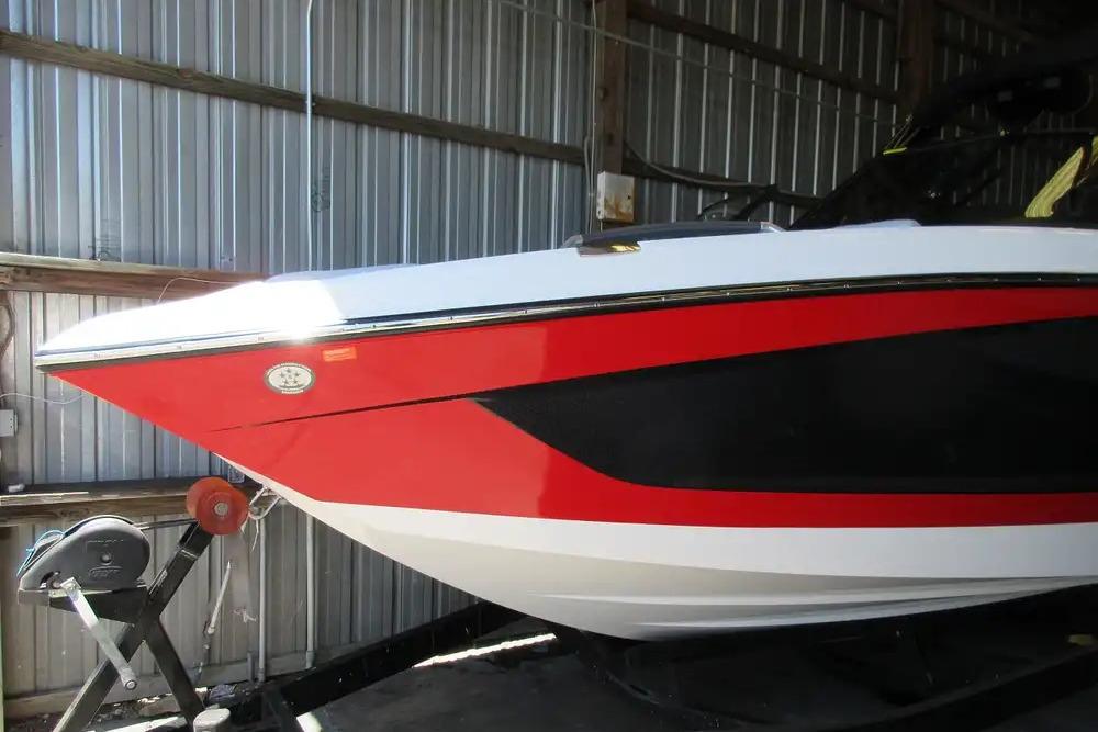 MasterCraft X24 2022 MasterCraft X24 boat with red and black accents in a storage facility.