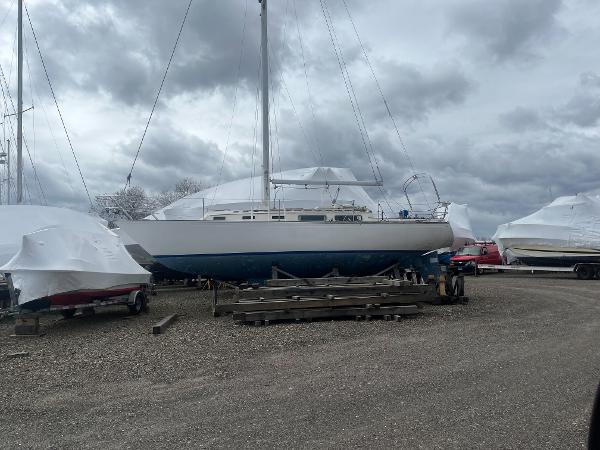 Sabre 34 1984 Sabre 34 sailboat on land, covered for storage under cloudy skies.
