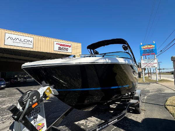 Regal LS4 Surf 2025 Regal LS4 Surf boat on trailer outside dealership.