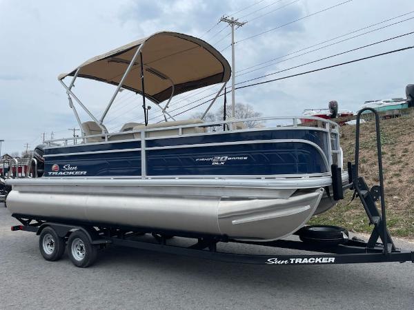 Sun Tracker Fishin' Barge 20 DLX 2025 Sun Tracker Fishin' Barge 20 DLX pontoon boat on trailer, side view.