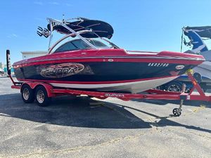 Supra 21 V 2009 Supra 21V LAUNCH boat on a red trailer in a parking lot.