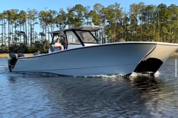 Front Runner 37 Catamaran 2024 Front Runner 37 Catamaran cruising on a calm lake with forested background.