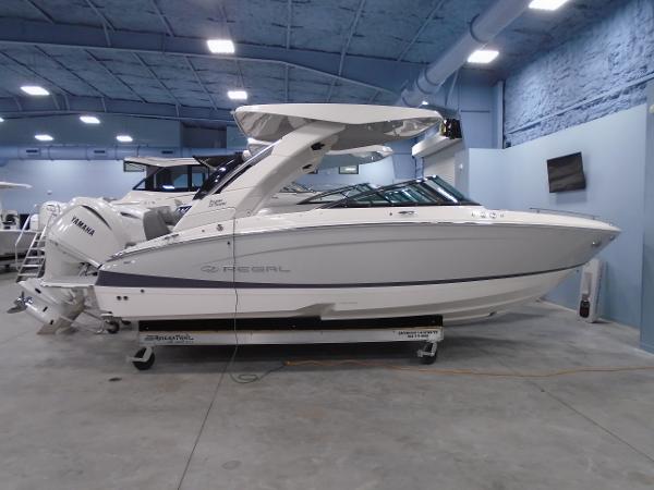 Regal LX4 2025 Regal LX4 boat in showroom, sleek white design, Yamaha engine, modern interior.