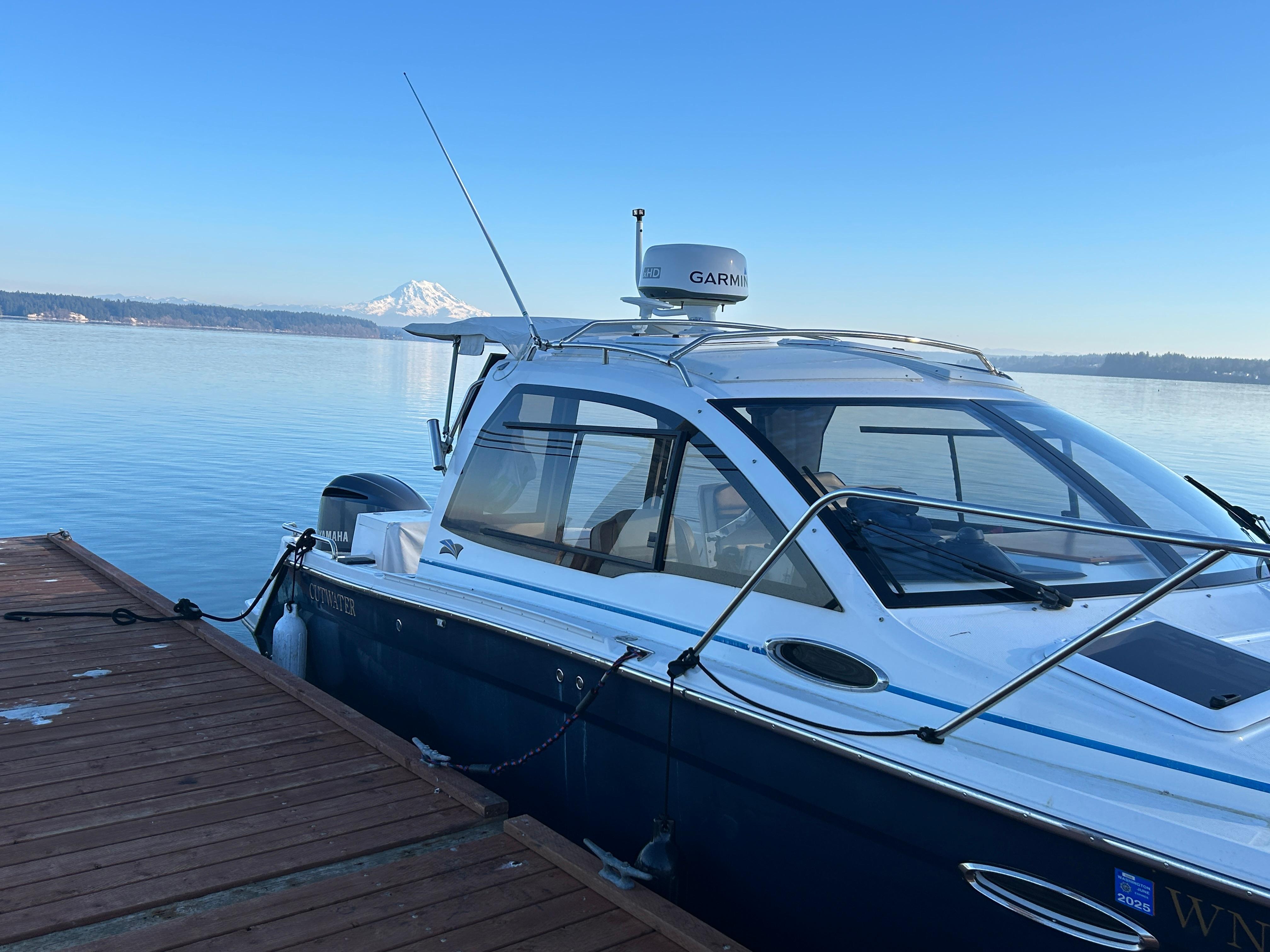 Cutwater C-242 Sport Coupe 2017 Cutwater C-242 Sport Coupe docked on calm water with mountain view.