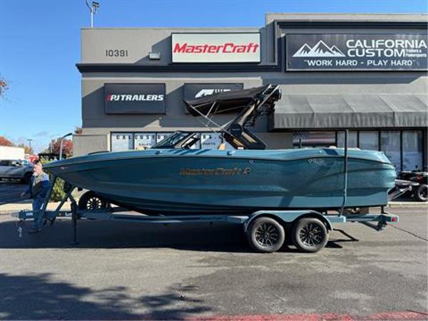MasterCraft X24 2025 MasterCraft X24 boat on trailer outside dealership.