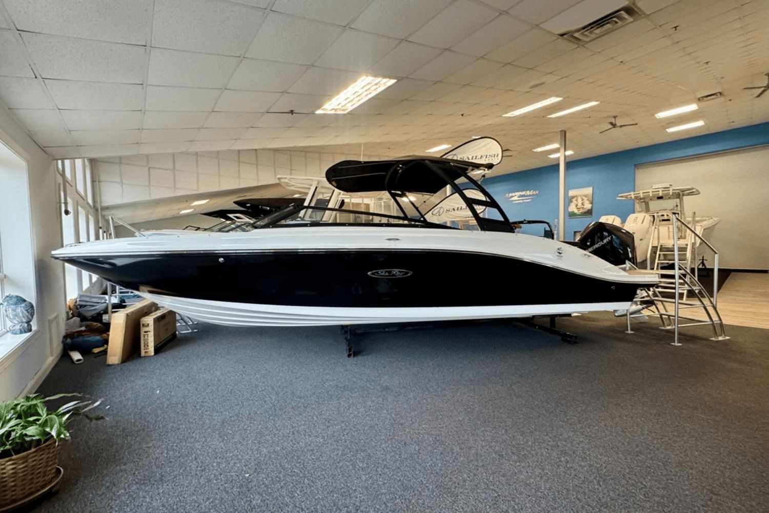 Sea Ray SPX 230 Outboard 2025 Sea Ray SPX 230 Outboard boat displayed in showroom, side view.