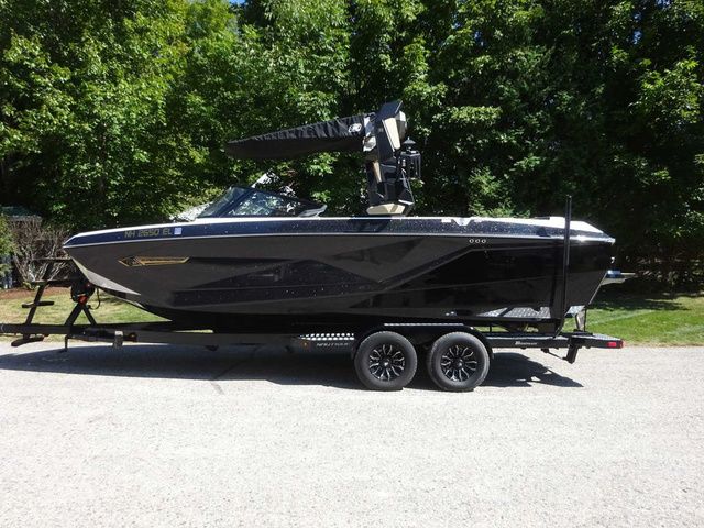 super air nautique G23 2024 Super Air Nautique G23 boat on trailer, parked outdoors.