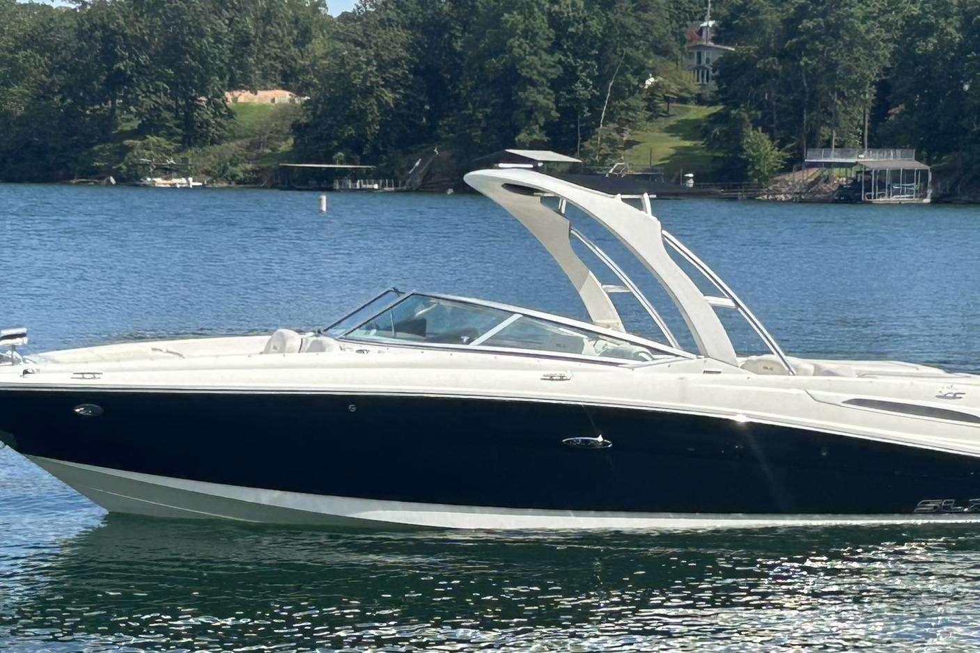Sea Ray 250 SLX 2007 Sea Ray 250 SLX boat on a serene lake with lush green surroundings.