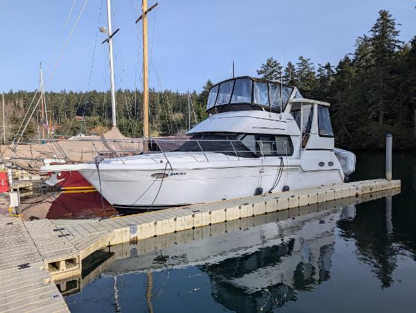 Carver 356 Aft Cabin Motoryacht 2001 Carver 356 Aft Cabin yacht docked at a marina with forested background.