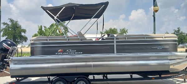 Sun Tracker Party Barge 24 DLX 2024 Sun Tracker Party Barge 24 DLX pontoon boat with canopy on trailer.