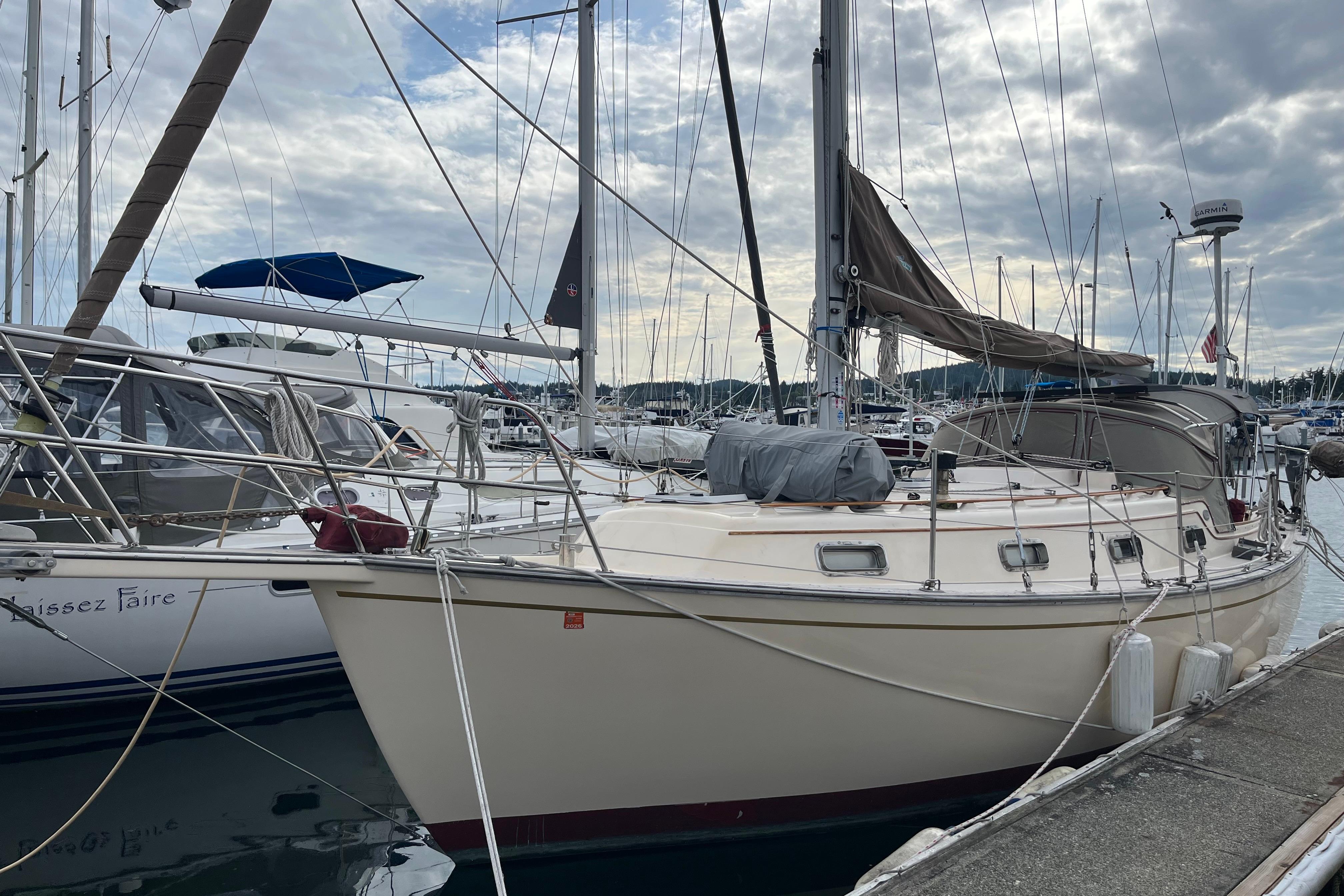 Island Packet 31 1989 Island Packet 31 sailboat docked at marina under cloudy sky.
