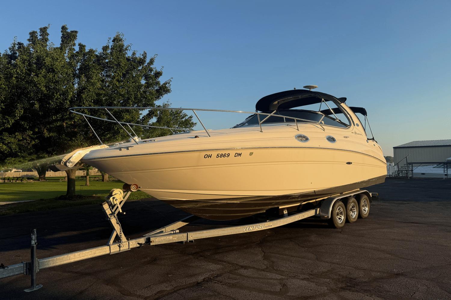 Sea Ray 280 Sundancer 2003 Sea Ray 280 Sundancer boat on trailer, parked outdoors in sunny setting.