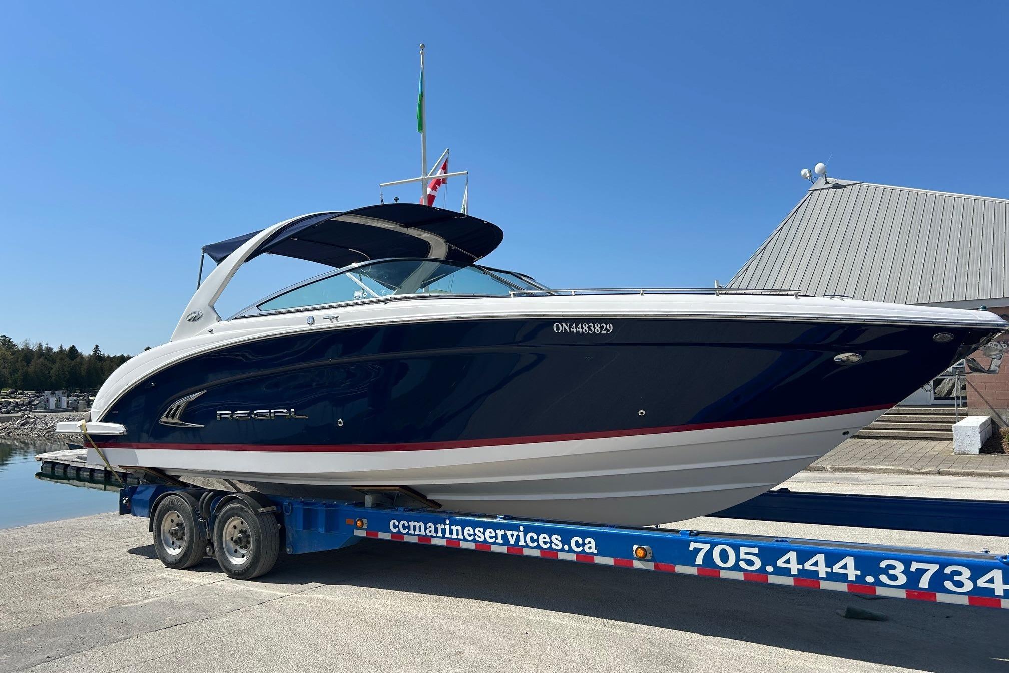 Regal 3200 Bowrider 2014 Regal 3200 Bowrider boat on trailer, blue and white design, sunny day.