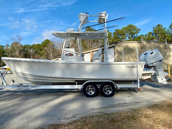 Pair Customs 24 DV 2022 Pair Customs 24 DV boat on trailer, parked outdoors with trees and building in background.