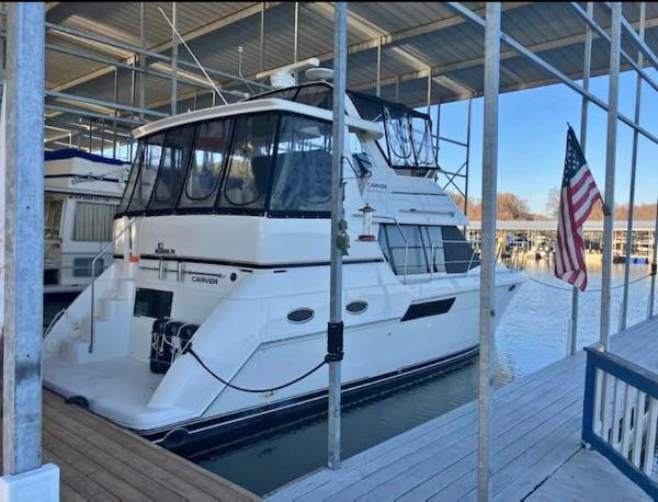 Carver 356 Motor Yacht 2001 Carver 356 Motor Yacht docked with American flag, under covered marina.
