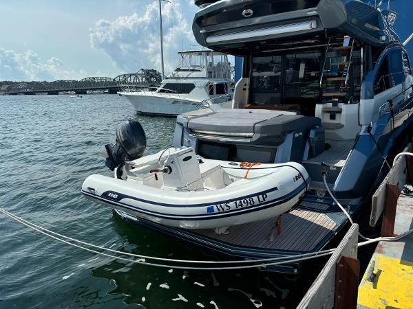 AB Inflatables Mares 11 2022 AB Inflatables Mares 11 boat docked beside a larger yacht on a sunny day.
