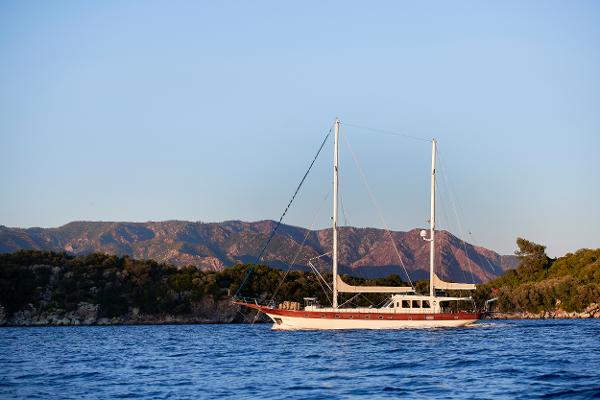 Bodrum GOULETTE Sailing yacht Bodrum GOULETTE 1998 on serene blue waters with scenic mountain backdrop.