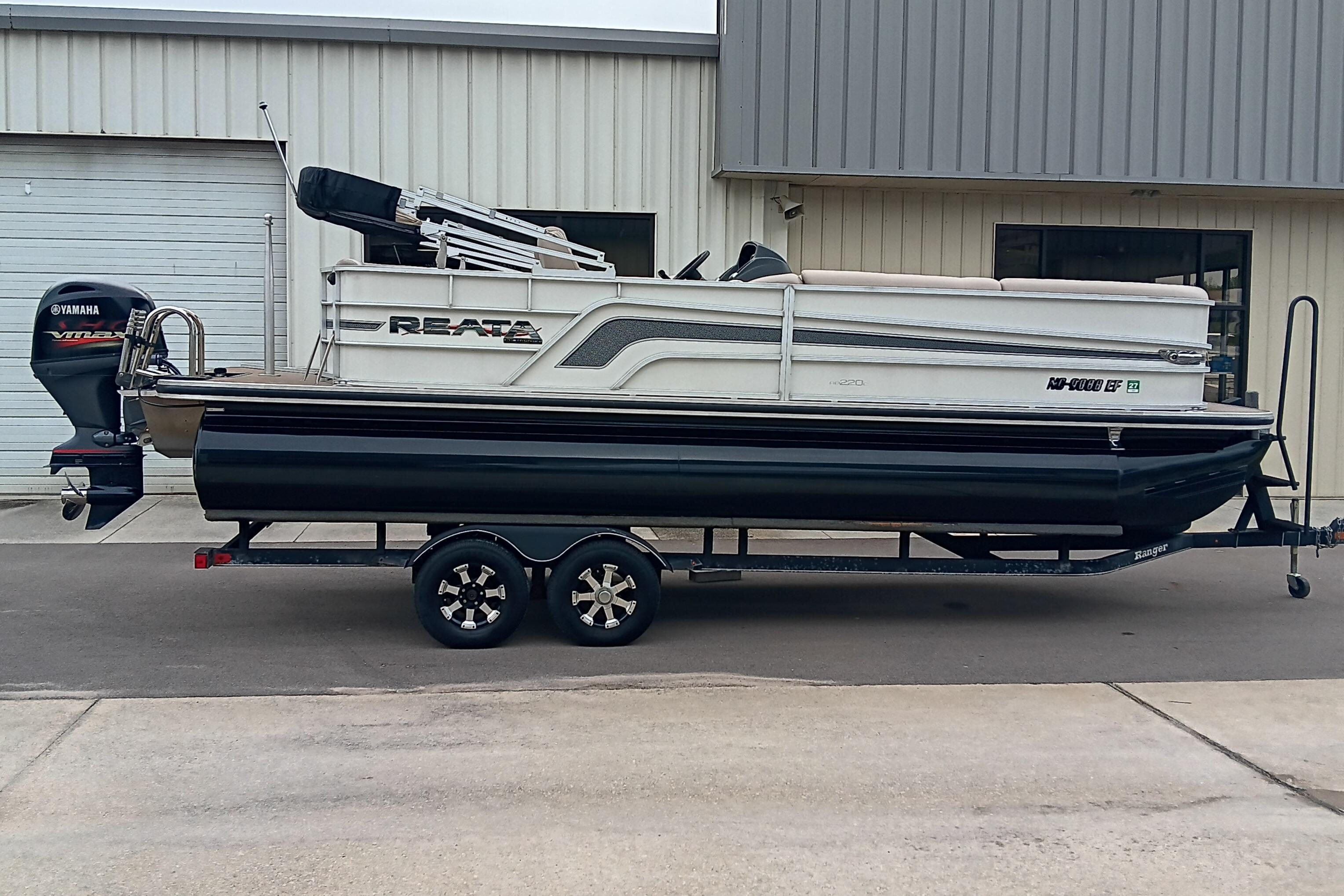 Ranger Reata 220C 2017 Ranger Reata 220C pontoon boat on trailer, parked outside a building.