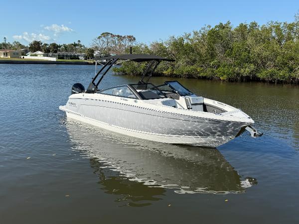 Cobalt R6 Outboard 2025 Cobalt R6 Outboard boat on calm water, surrounded by lush greenery.
