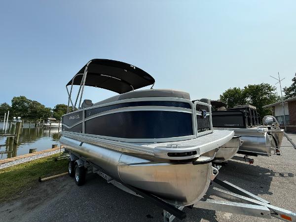 Premier 200 Sunscape RE XLC Tritoon 2025 Premier 200 Sunscape RE XLC pontoon boat on trailer, parked near a waterfront.