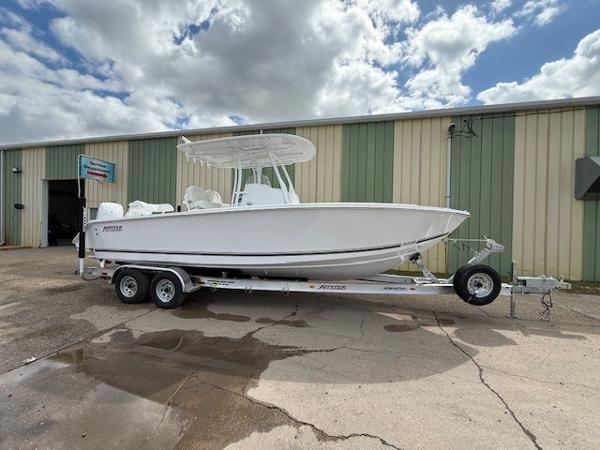 Jupiter 26 FS 2025 Jupiter 26 FS boat on trailer, parked outside industrial building under cloudy sky.