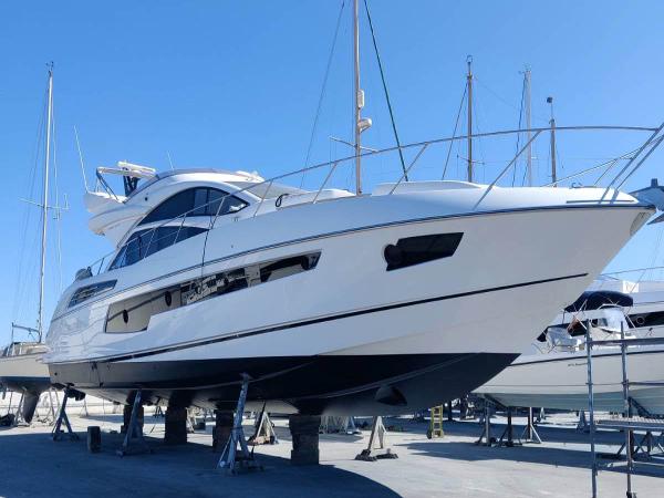 Sunseeker 68 Sport Yacht 2015 Sunseeker Sport Yacht 68 on dry dock, sleek design, blue sky background.