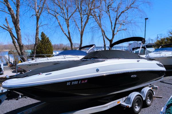 Sea Ray 240 Sundeck 2012 Sea Ray 240 Sundeck boat on trailer, parked outdoors near trees.
