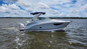 Regal 26 XO 2020 Regal 26 XO boat cruising on a lake under a partly cloudy sky.