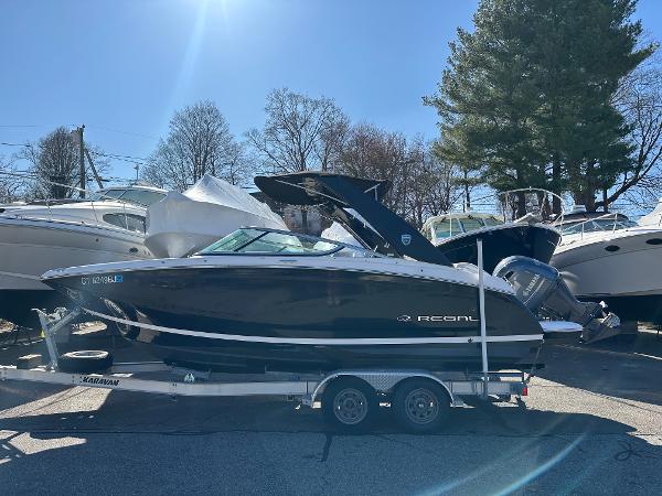 Regal 23 OBX 2018 Regal 23 OBX boat on trailer, parked outdoors under sunlight.