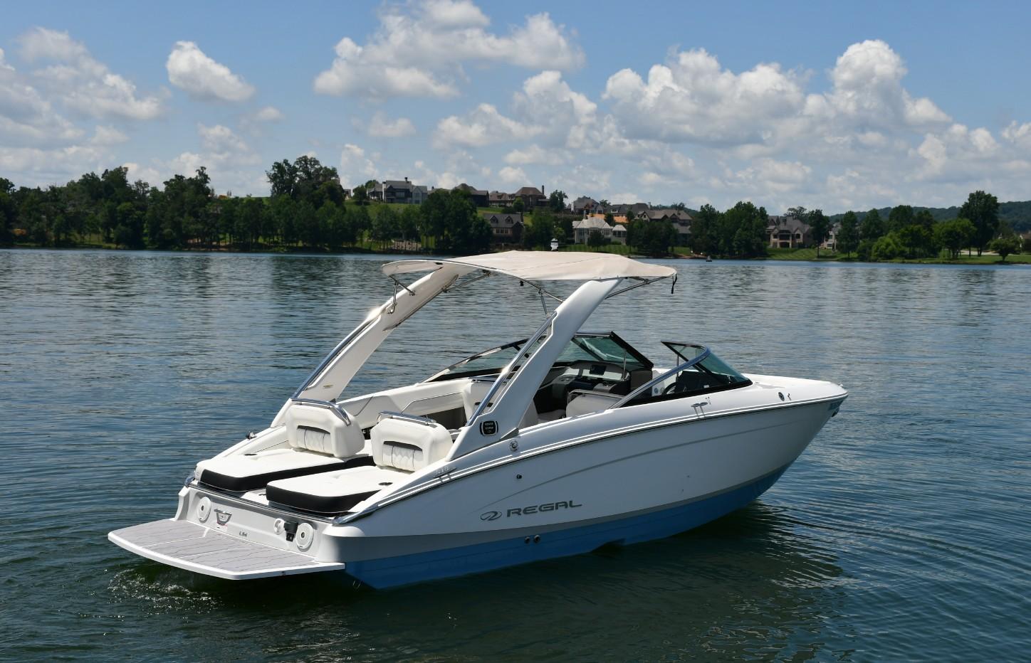 Regal LS4 2019 Regal LS4 boat on a serene lake under a partly cloudy sky.