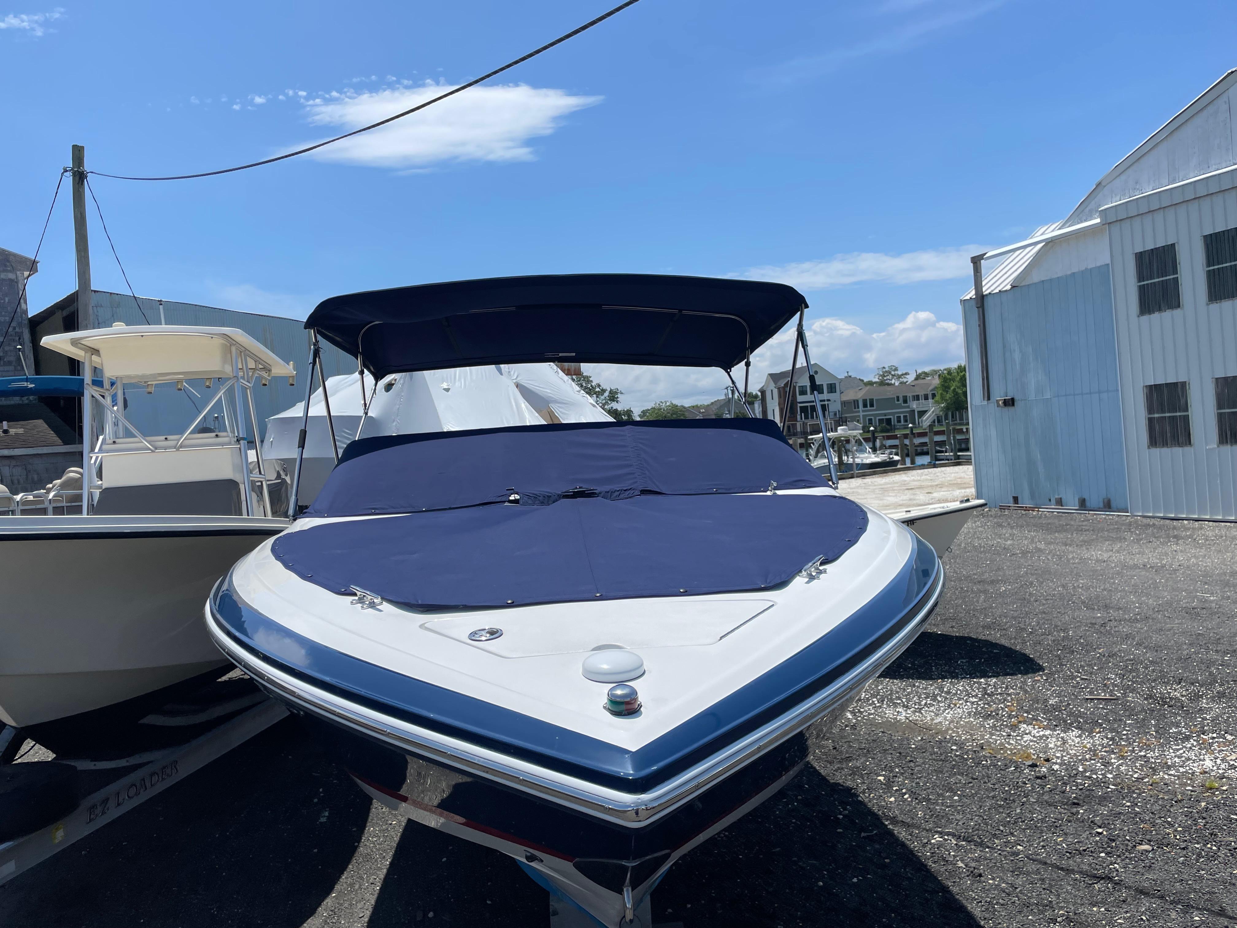 Cobalt 226 2004 Cobalt 226 boat with blue cover, parked outdoors on a sunny day.