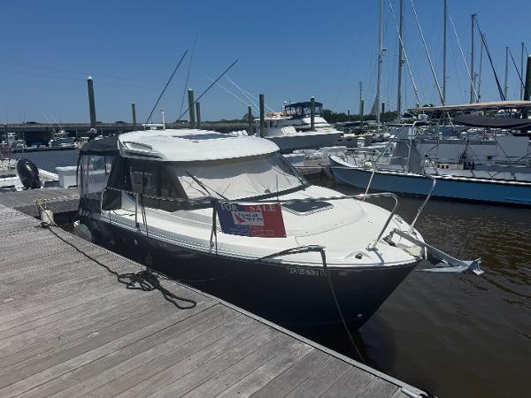 Jeanneau NC 695 2019 Jeanneau NC 695 boat docked, for sale sign visible.