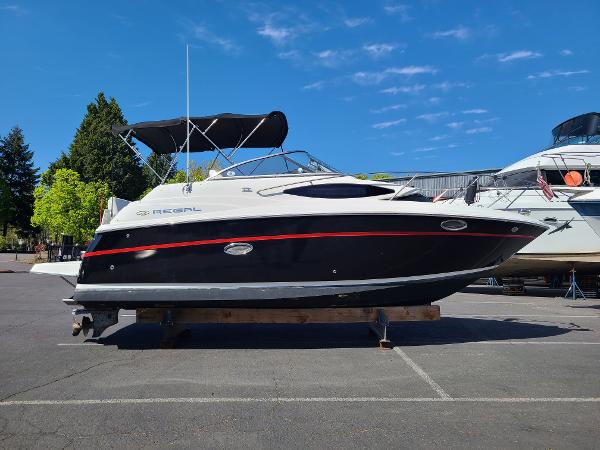 Regal 2565 2008 Regal 2656 boat on display in a parking lot under a clear blue sky.