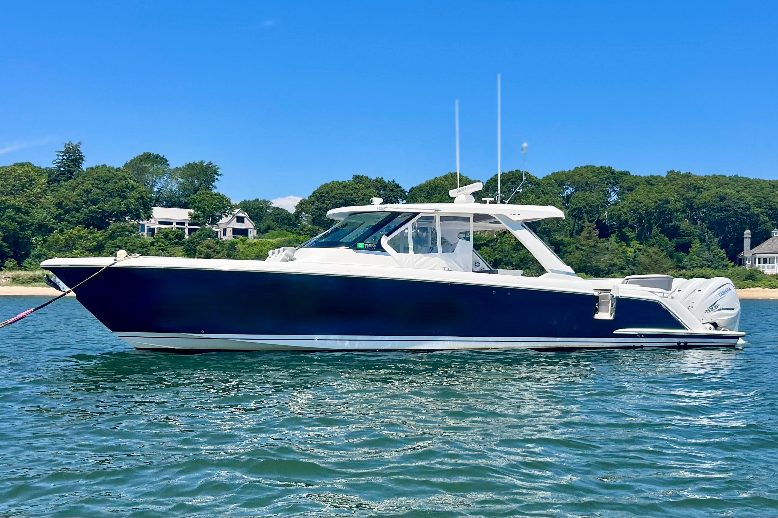 Tiara Yachts 43 LS 2020 Tiara Yachts 43 LS boat on water, surrounded by lush greenery and clear blue sky.