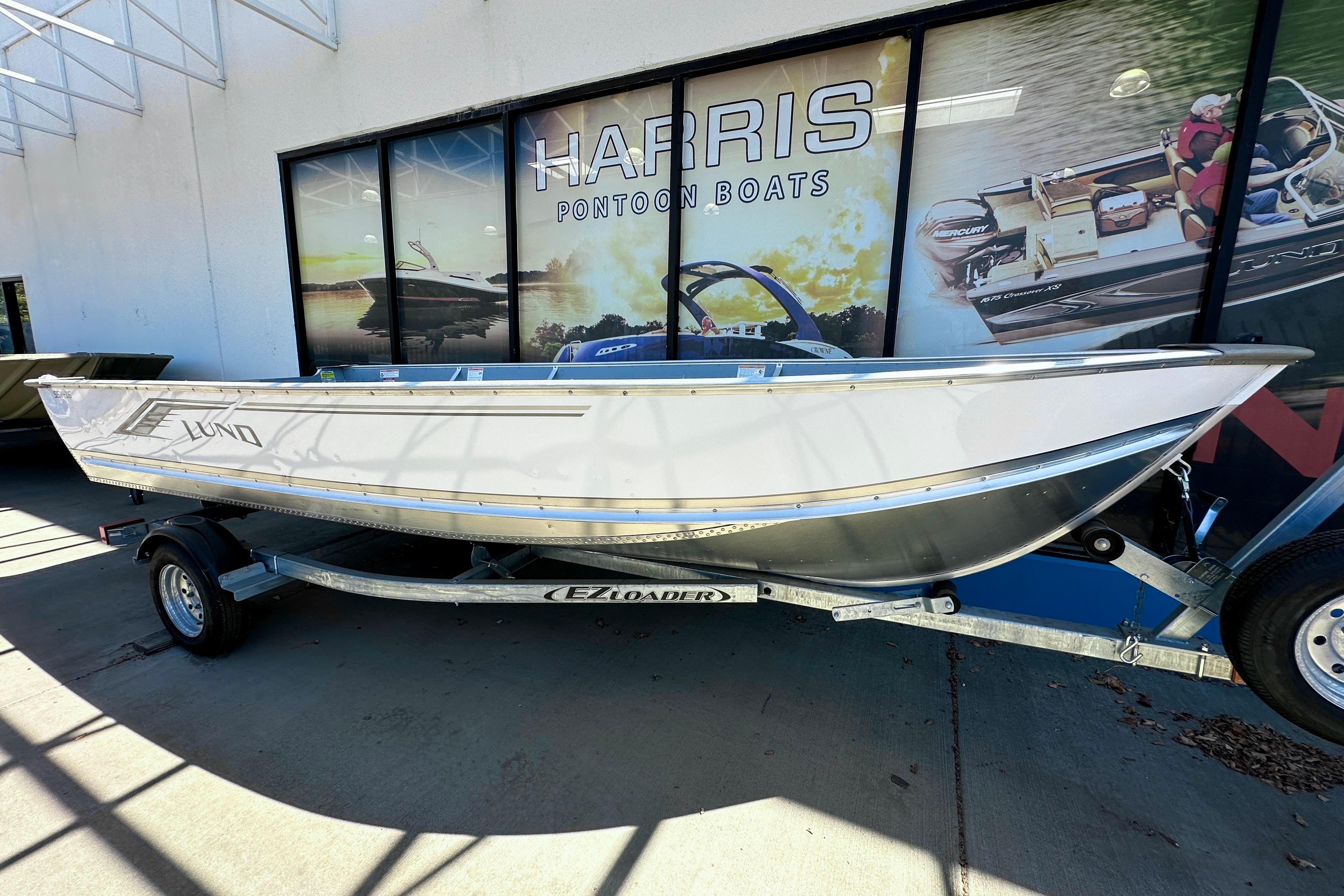 Lund SSV-16 2025 Lund SSV-16 boat on trailer outside Harris Pontoon Boats showroom.