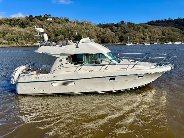 Jeanneau Prestige 32 Flybridge 2003 Jeanneau Prestige 32 Flybridge yacht on a calm river.