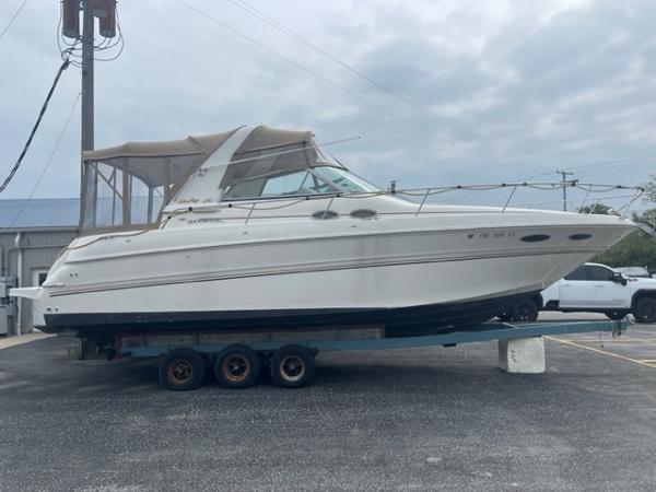 Sea Ray 310 Sundancer 1999 Sea Ray 310 DA boat on a trailer in a parking lot.