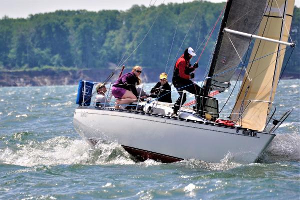 Abbott 33 Sailboat Abbott 33 (1987) navigating choppy waters with crew, lush shoreline in background.
