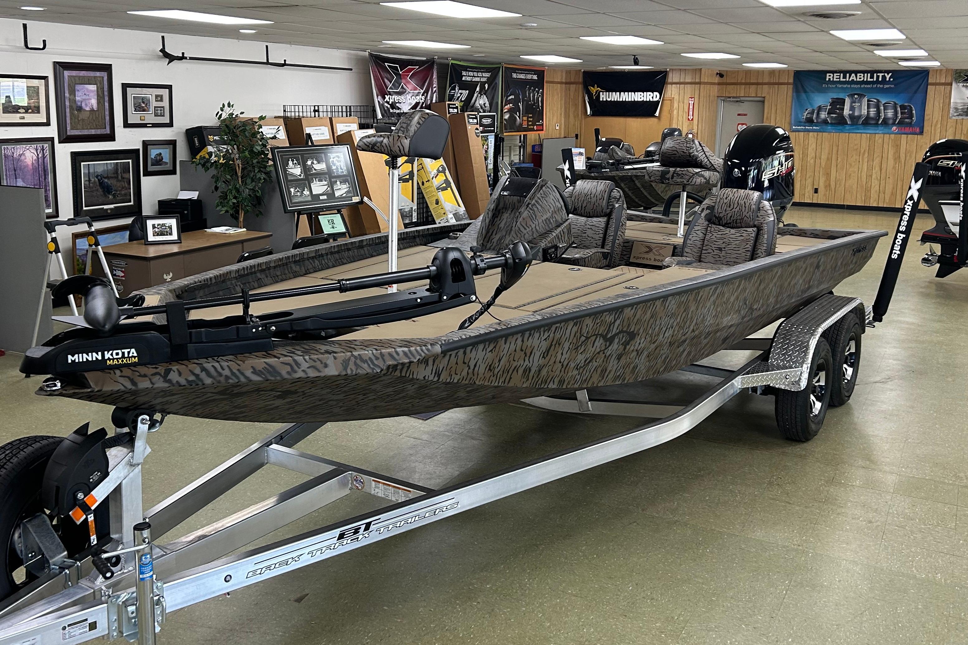 Xpress H20 Bass 2026 Xpress H20 Bass boat in showroom, featuring Minn Kota Maxxum trolling motor.