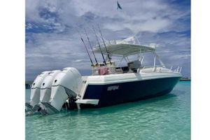 Intrepid 377 Walkaround 2006 Intrepid 377 Walkaround boat in clear turquoise water, featuring triple outboard engines.