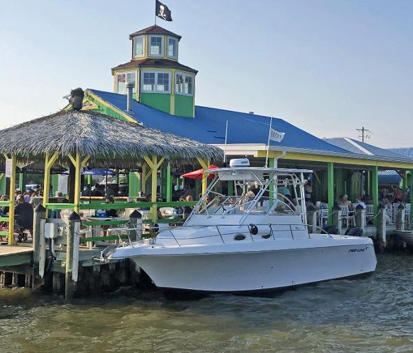 Pro-Line 30 Wa 2003 Pro-Line 30 WALK boat docked near a vibrant waterfront restaurant.