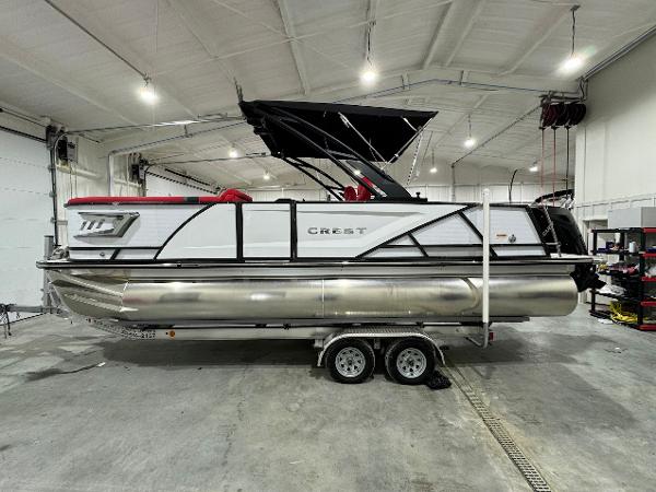 Crest Caribbean RS 230 SLRC 2024 Crest Caribbean RS 230 SLRC pontoon boat in a showroom.