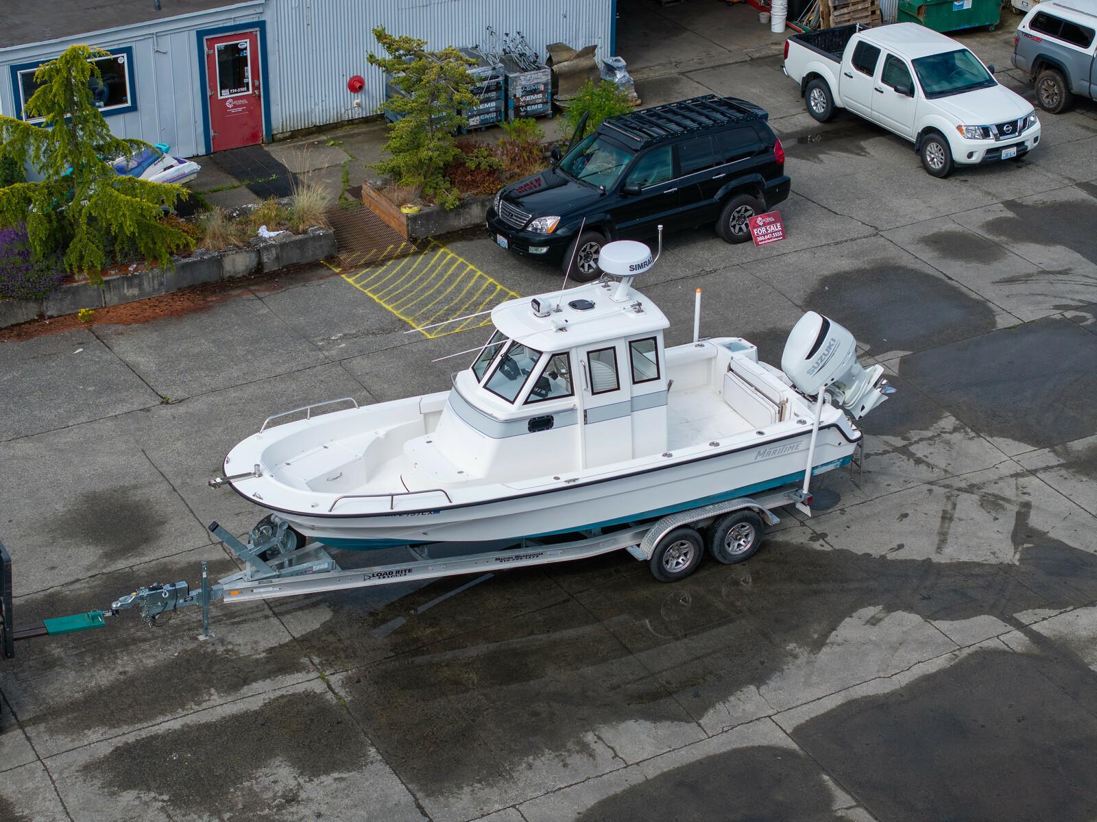 Maritime 250 Voyager 2021 Maritime 250 Voyager boat on trailer in parking lot, surrounded by vehicles.