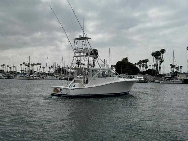 Luhrs 41 Express 2007 Luhrs 41 Express boat in marina with cloudy sky and palm trees.