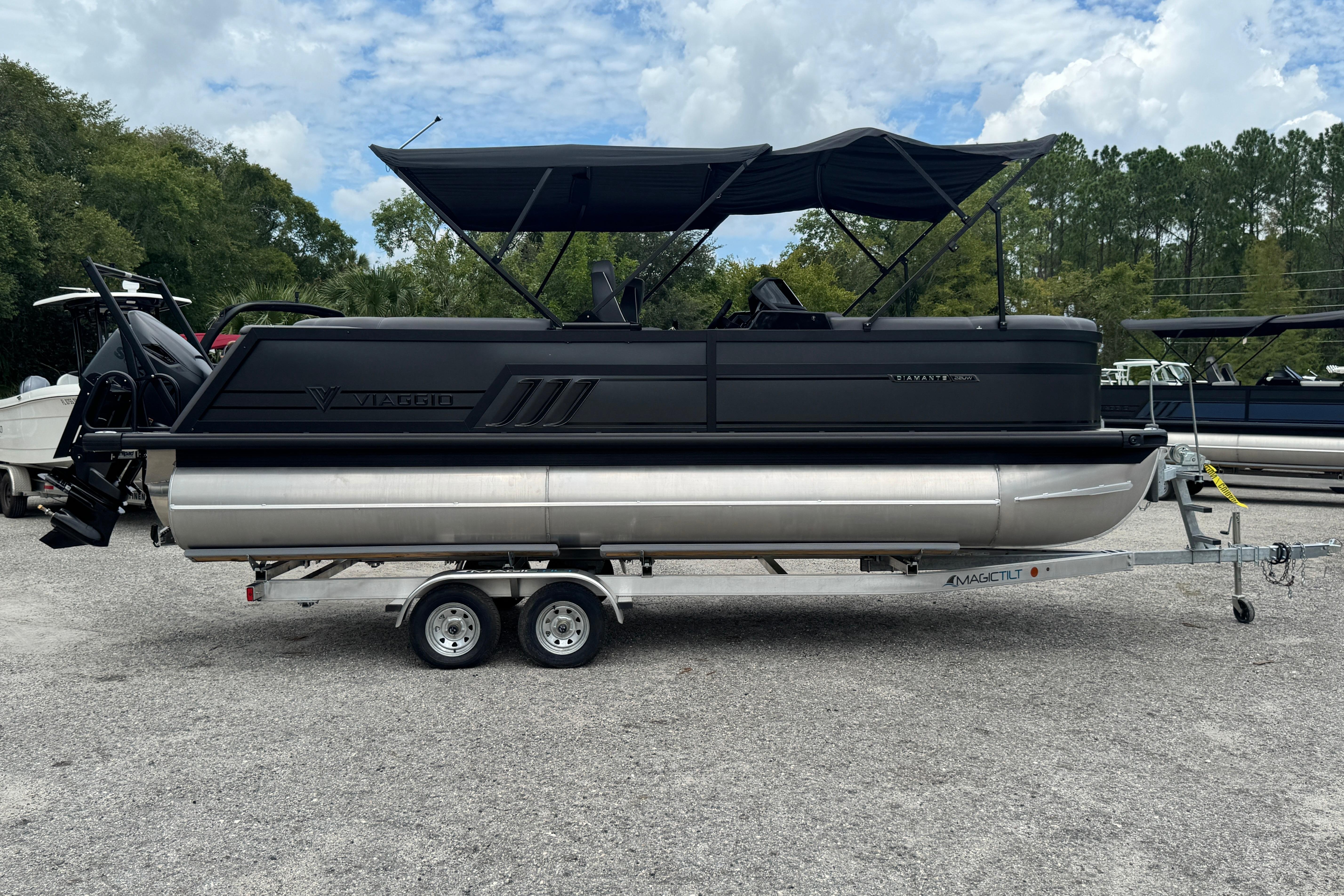 Viaggio D22UW 2026 Viaggio D22UW pontoon boat on trailer, parked outdoors under cloudy sky.